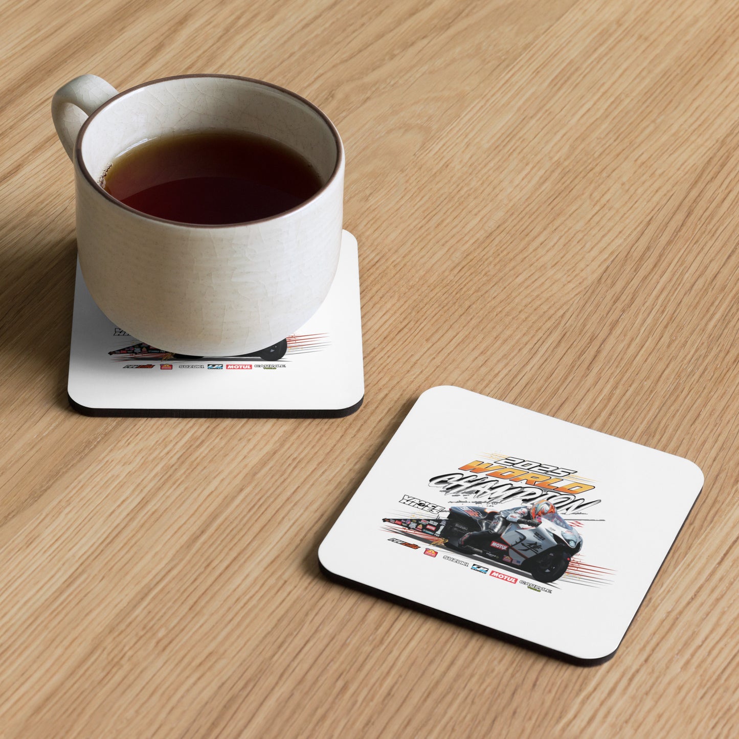 Cork-back coaster with white top featuring racing motorcycle graphic under a mug